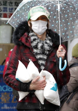  日本地震灾区民众雨中排队购买生活必需品